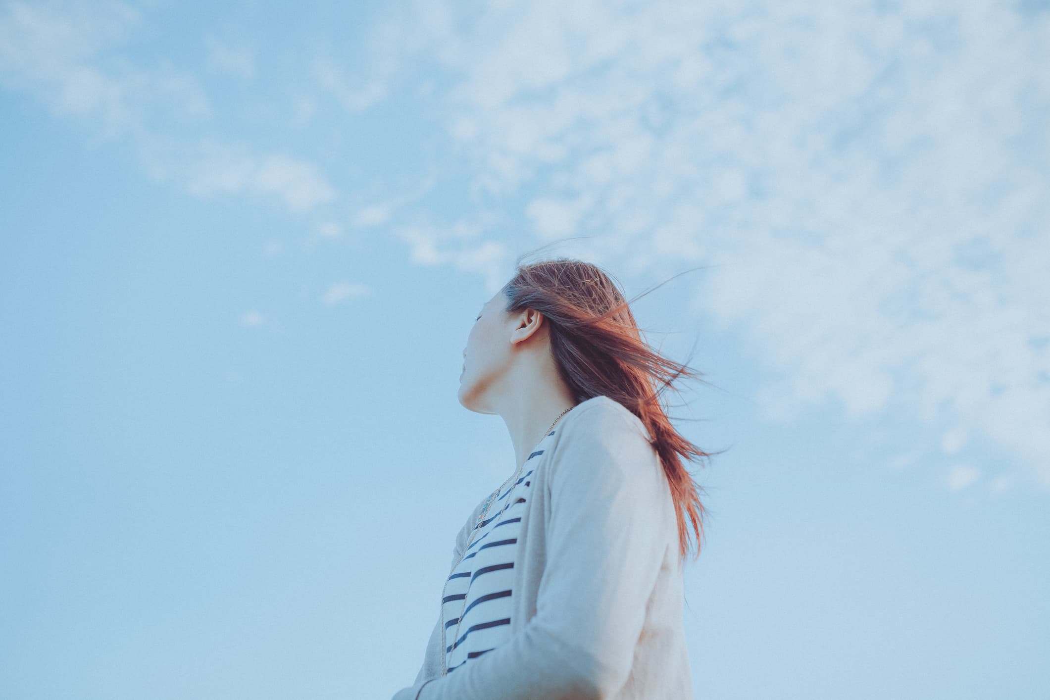 The sky is blue and the person is looking up. Feeling inspired and looking forward to the future.