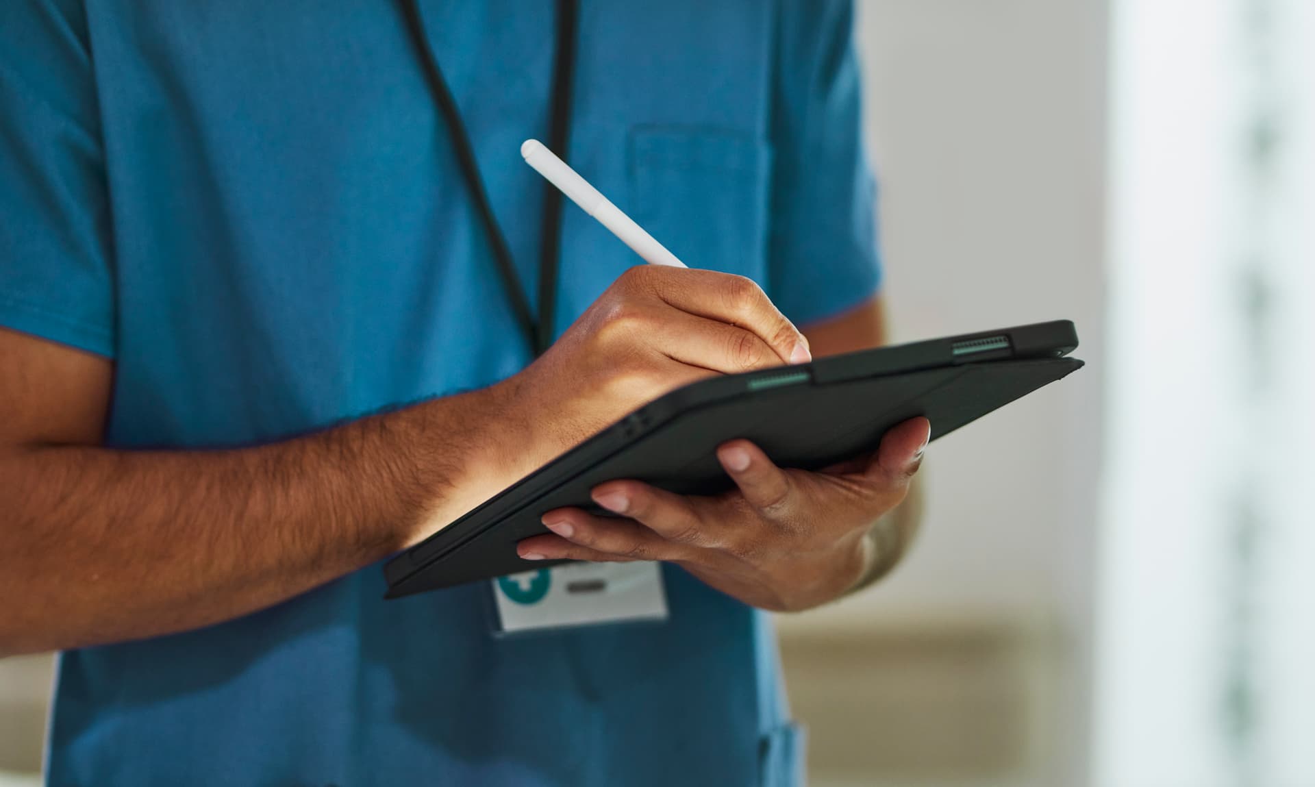 a nurse writing on a tablet